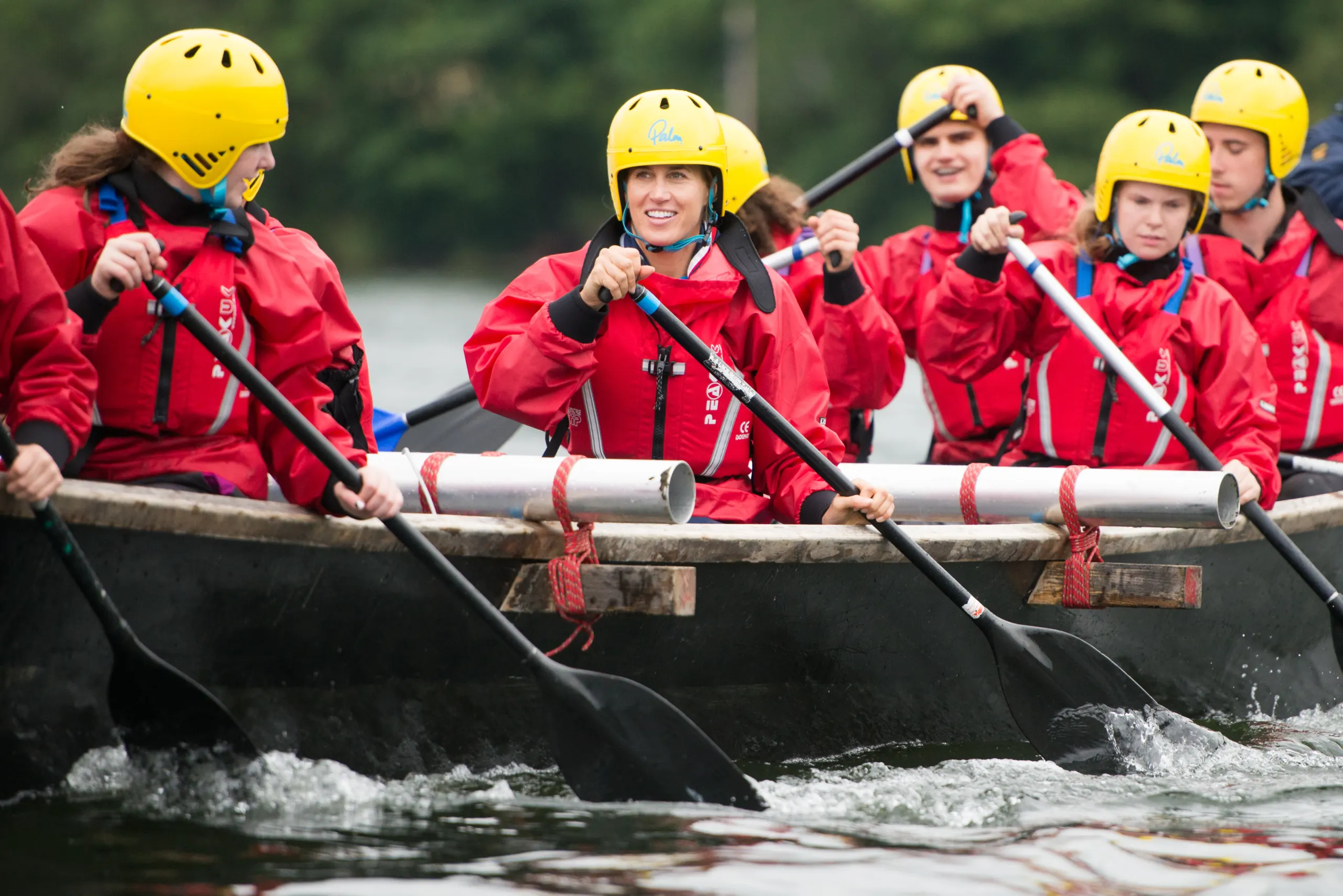 Scouts in red buoyancy aids rowing on the water