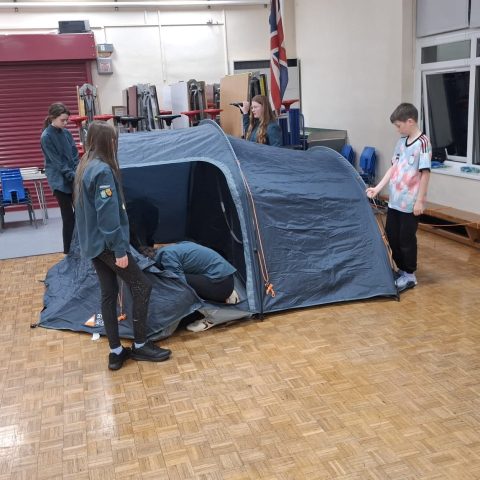Scouts checking inside a newly pitched tunnel tent